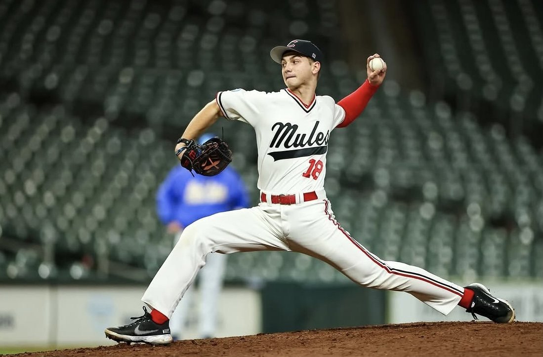 Mules pitcher number 18 in the white script jersey delivering a pitch